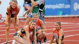 Friederike Möhlenkamp, Laura Müller, Lara Hofmann und Ruth Sophia Spelmeyer (v.l.) gucken nach der 4x400 m Staffel bei der Europameisterschaft in Amsterdam auf die Anzeigetafel. © imago 
