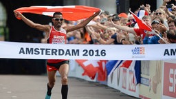 Halbmarathonläufer Tadesse Abraham jubelt über seinen Sieg bei den Europameisterschaften in Amsterdam. © imago Foto: Jan Hübner