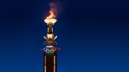 Der Marathonturm mit der olympischen Flamme.  
