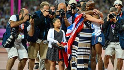 Mohamed Farah feiert zusammen mit Ehefrau Tania Nell und Tochter Rihanna den Sieg über 10.000 Meter bei den Olympischen Spielen 2012 in London. © Witters Foto: MatthiasHangst
