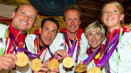 Die Vielseitigkeitsreiter Michael Jung, Dirk Schrade, Peter Thomsen, Ingrid Klimke and Sandra Auffarth (v.l.) präsentieren ihre Gold-Medaillen im Deutschen Haus. © picture alliance / dpa Foto: Peter Kneffel