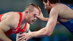 US-Ringer Kyle Snyder (l.) bekommt den Finger seines Kontrahenten Albert Saratow aus Rumänien ins Auge. © imago/ZUMA Press