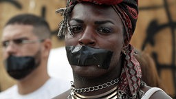 Eine Protestaktion in Rio, die auf die Lebensumstände in den Favelas aufmerksam machen soll. © dpa Foto: Barbara Walton