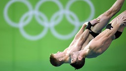 Die US-amerikanischen Wasserspringer Steele Johnson (l.) und David Boudia springen ins Wasser.  © dpa Bildfunk Foto: Felix Kästle