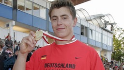 Kugelstoßer David Storl präsentiert seine Goldmedaille der Juniorenweltmeisterschaften 2008 in Bydgoszcz.  © imago sportfoto